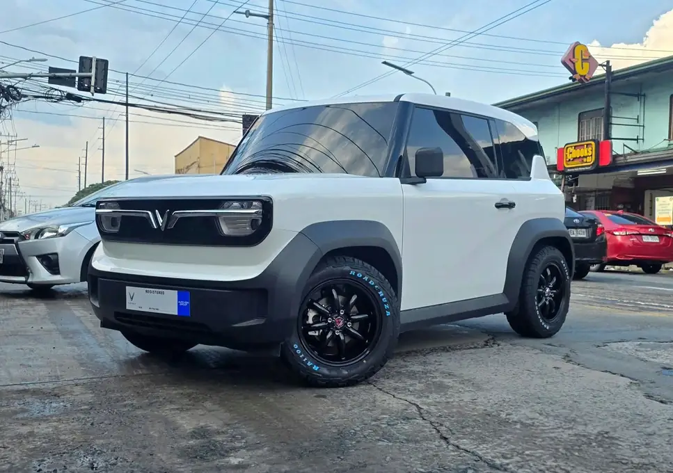 A white compact SUV on black mags outside the shop