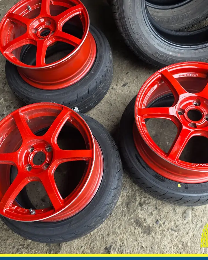 A set of red six-spoke mags with tires, ready to fit