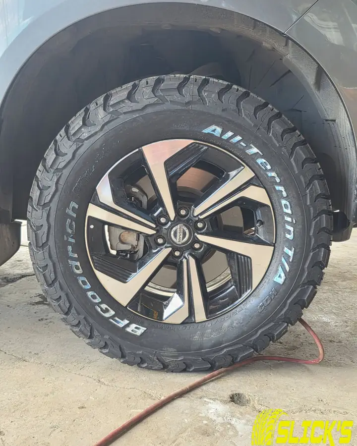 An all-terrain tire fitted on an SUV at the shop